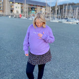 Anwen wearing a lavender sweatshirt with the song lyrics Fel Hyn 'Da Ni Fod by Bwncath